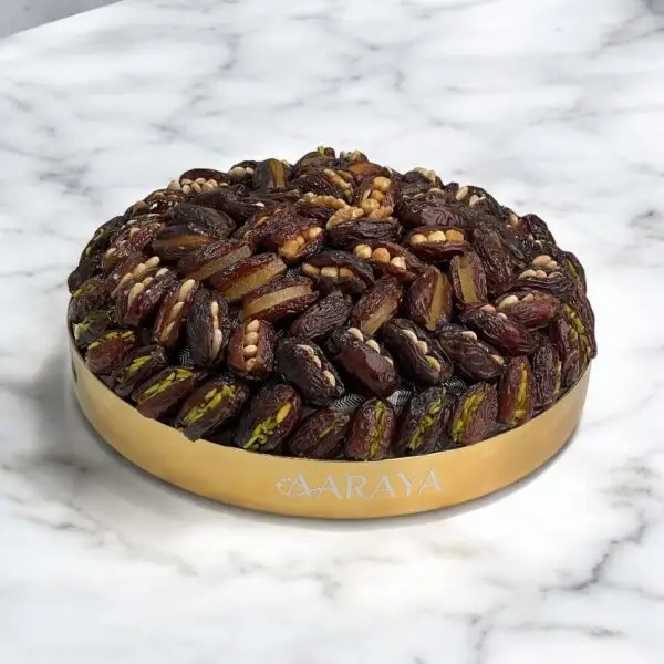 The AARAYA® Luxury Assorted Dates Tray Gilded Majesty is an exquisite 36 cm gilded tray featuring 1.7 kg of hand-picked luxury dates with premium fillings like pistachio ganache, salted hazelnut, and more. Perfect for Ramadan, gifting, or special occasions, this elegant tray combines sophistication and gourmet indulgence. Product Features: Premium Assorted Fillings: Walnut, Lemon Peel, Cashew, Orange Peel, Pistachio, Feuilletine Crunch, Pistachio Ganache, Almond, Salted Hazelnut Tray Dimensions: 36 cm Dates Weight: 1.7 kg Total Weight: 2.6 kg Elegant Design: Encased in a luxurious gilded tray Award-Winning Quality: Great Taste Awards 2022 & 2023 Allergen Information: Contains nuts and dairy. Produced in a facility that handles gluten and soy.