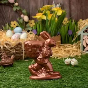AARAYA® Walking Bunny Easter Basket 14 CM – a handcrafted chocolate sculpture featuring a walking bunny carrying a basket of Easter eggs, made from premium couverture chocolate. A luxurious and whimsical Easter creation.