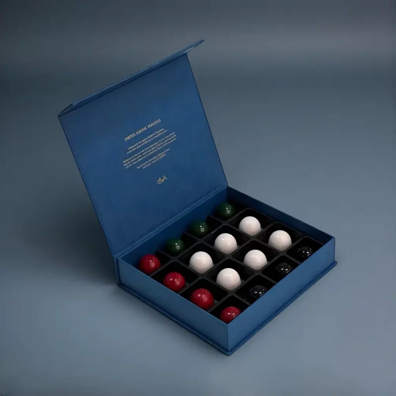 Royal blue luxury AARAYA® chocolate box containing 16 artisanal chocolates arranged in UAE National Day colours.