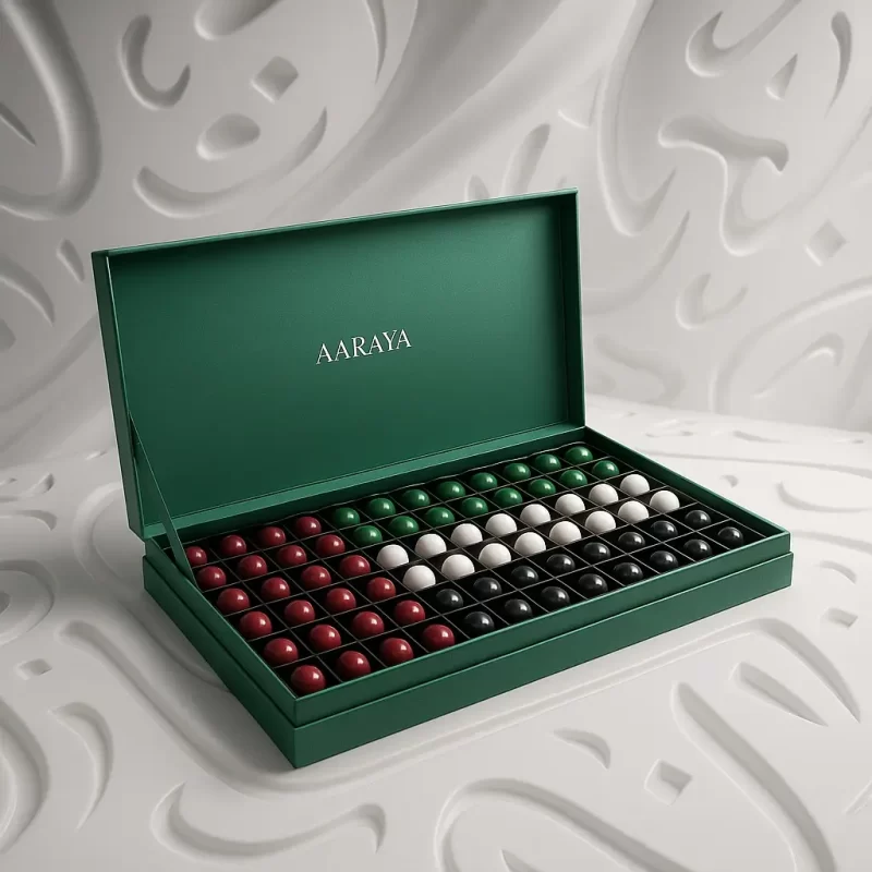 AARAYA® Luxury UAE National Day Chocolate Box -Flag Edition, featuring 230 artisanal chocolates arranged in UAE flag colors inside an elegant long white luxury box with gold detailing, displayed on a white embossed background