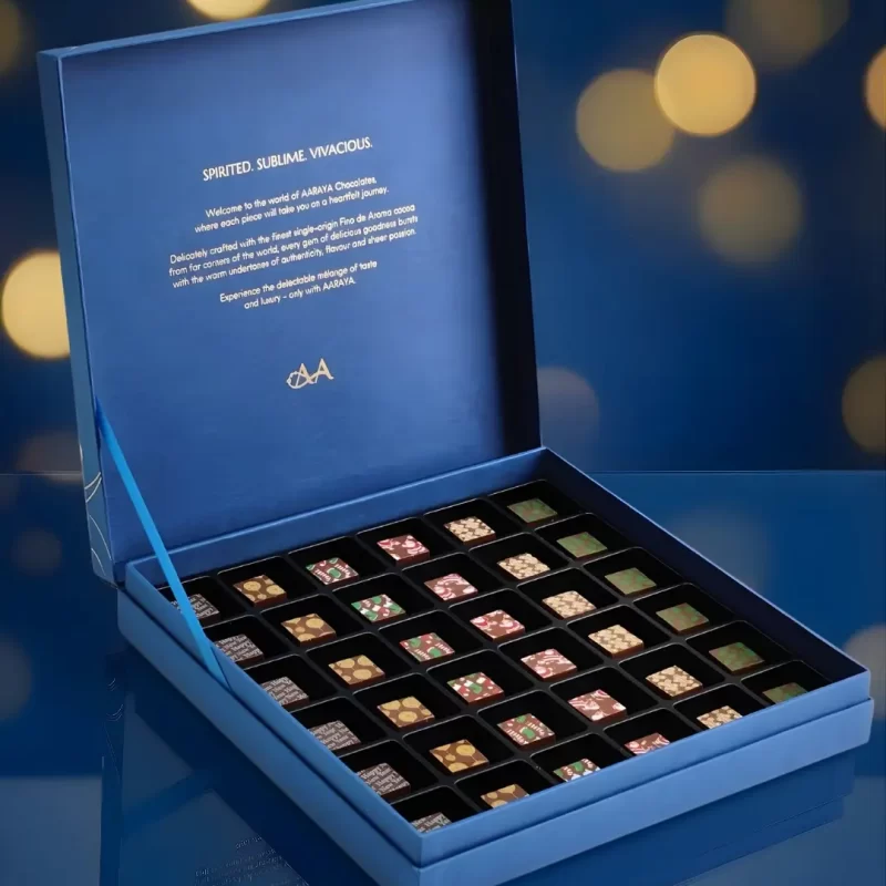 Luxury blue Christmas chocolate gift box by AARAYA® featuring 36 handcrafted festive chocolates arranged in an elegant presentation box