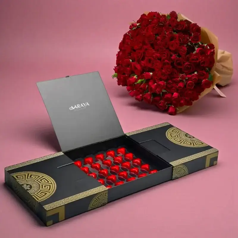 AARAYA® Luxury Noir Valentine’s Heart Chocolates with red heart-shaped chocolates in a black luxury box paired with a romantic red rose bouquet for Valentine’s Day gifting