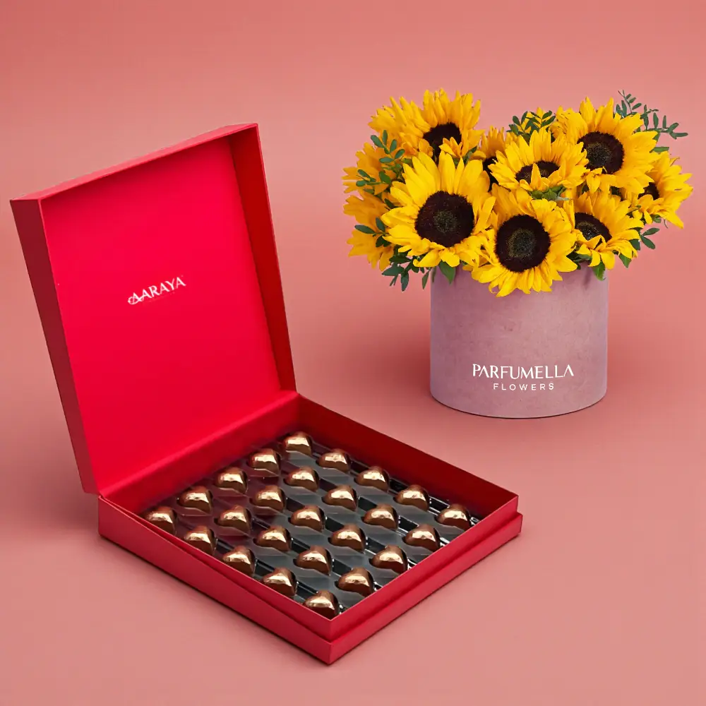 Luxury Valentine’s chocolate gift box with golden heart chocolates paired with sunflowers in a premium hatbox by AARAYA®